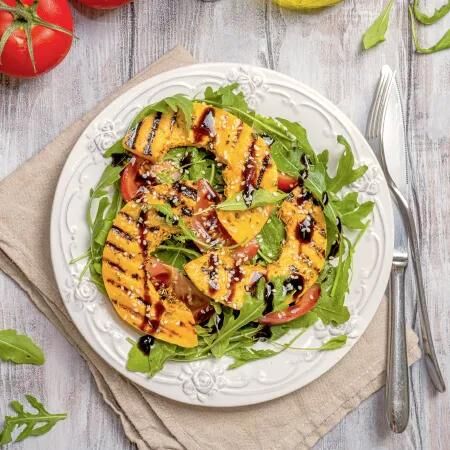Gegrillter K&uuml;rbis auf Rucola und Tomaten, mit Balsamico garniert &ndash; herbstlicher Salat voller Geschmack und Vitamine.