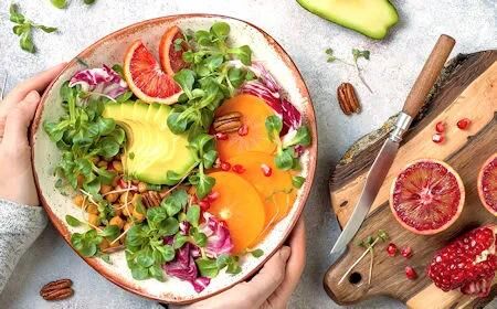 Bunte Bowl mit Avocado, Blutorange, Kichererbsen, Feldsalat und Granatapfel – Symbolbild für gesunde Ernährung und bewusste Vorsätze im neuen Jahr.