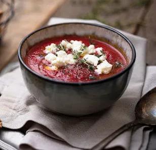 Rote-Bete-Suppe mit zerbr&ouml;seltem Feta und frischem Thymian in einer Steingut-Schale.