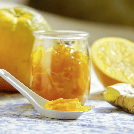 Hausgemachte Ingwer-Orangen-Marmelade im Glas mit frischen Zutaten