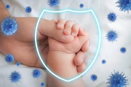 Eine große und eine kleine Hand halten sich schützend, umgeben von stilisierten blauen Viren. Überlagert ist ein leuchtendes Schild-Symbol, das symbolisch für Immunschutz steht.