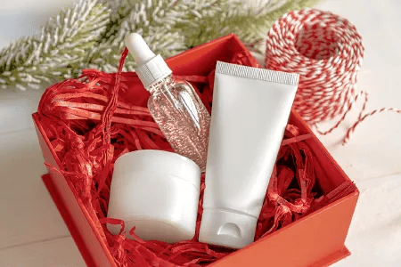 Geschenkbox mit Kosmetikprodukten und weihnachtlicher Dekoration.