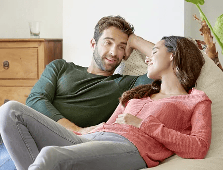 Paar sitzt entspannt auf dem Sofa und unterh&auml;lt sich vertraut