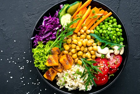 Vegane Bowl mit frischem Gem&uuml;se, H&uuml;lsenfr&uuml;chten und Reis.